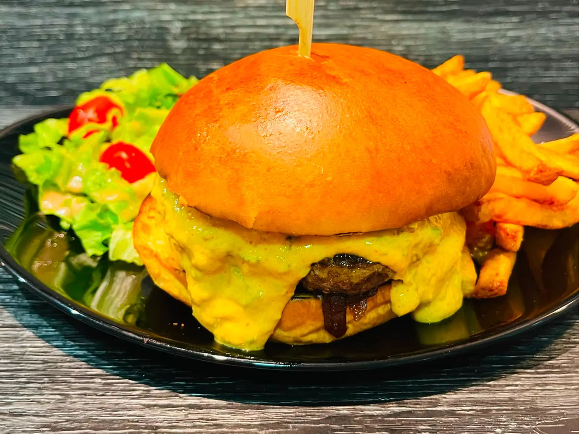 Burger maison, steak 180g, fromage des Petits Monts et oignons confits, frites maison, salade et tomates