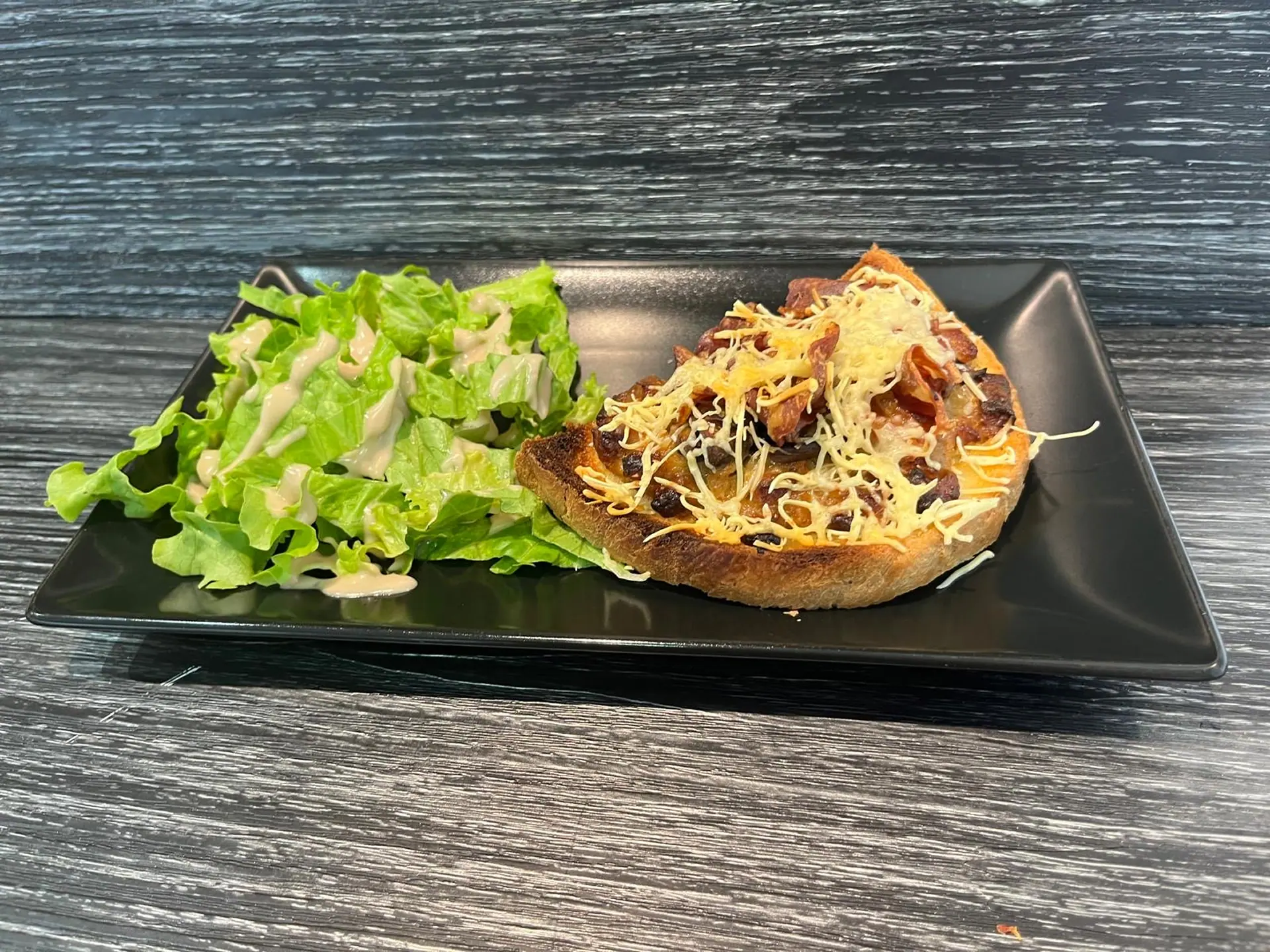 Tartine gratinée aux oignons, lardons et coppa, champignons et salade verte